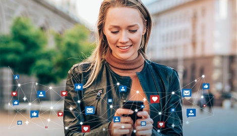 Eine Frau hält Smartphone in der Hand und postet Nachrichten in sozialen Netzwerken