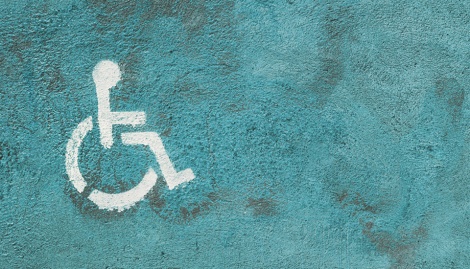 Weißes Rollstuhlfahrer-Symbol auf türkisblauem Hintergrund