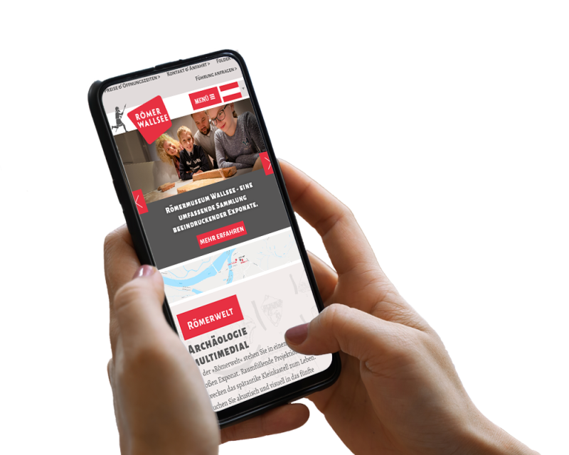 Hand h&auml;lt Smartphone, darauf ist ein Screenshot der Website zu sehen