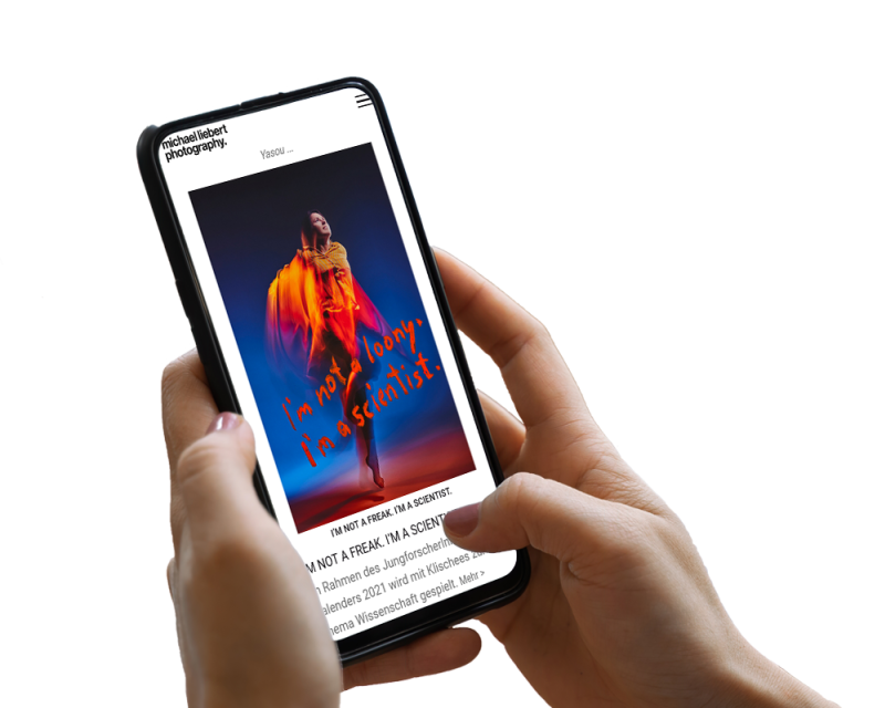 Hand h&auml;lt Smartphone, darauf ist ein Screenshot der Website zu sehen