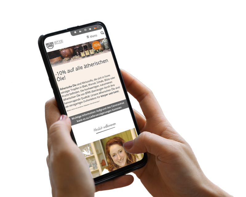 Hand h&auml;lt Smartphone, darauf ist ein Screenshot der Website zu sehen