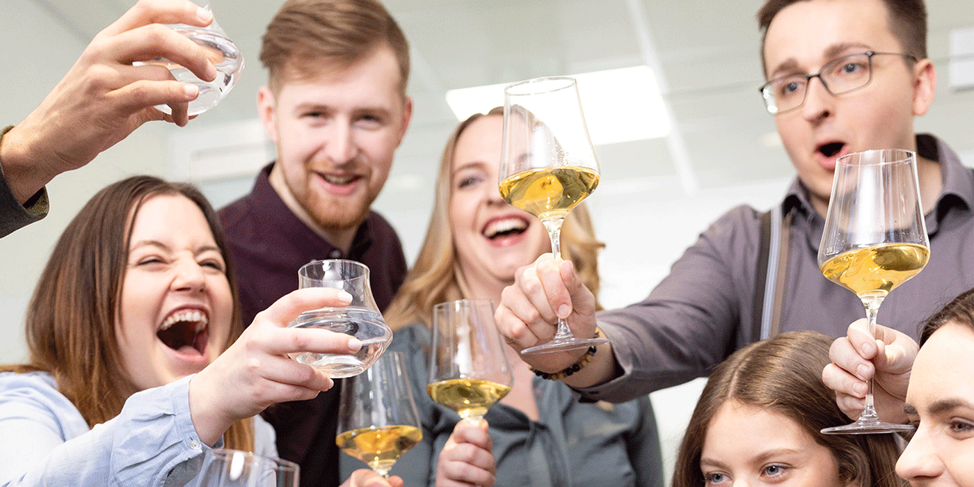 Gruppe von Menschen feiert und stoßt mit Weingläsern an