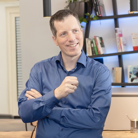 Anton Mayringer in einem Büro mit Bücherregal dahinter