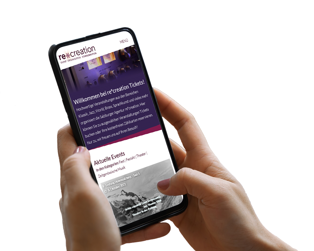 Hand hält Smartphone, darauf ist ein Screenshot der Website zu sehen