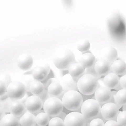 Man sieht eine Nahaufnahme weißer Kunststoffkugeln auf weißer Oberfläche.