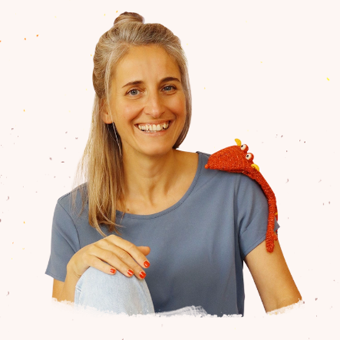 Sympathisches Portrait einer blonden Frau mit einer Sockenpuppe auf dem Kopf